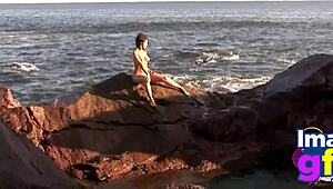 Hot brunette babe in lingerie on beach