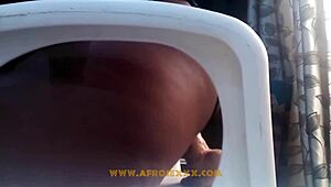 African woman in mini skirt pleasures herself on chair