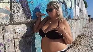 Milf plays with her big tits and ass on public beach