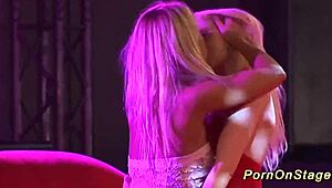 Blondes ripping clothes in intense lesbian sex show on public outdoor stage with dildos and voyeurs watching