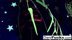 Sexy pornstar Dani casually plays with her wet pussy in a group setting.