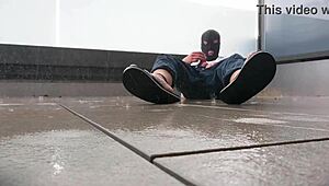 Masked babe jerks off wildly on wet balcony