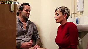 Damn! Busty Tattooed MILF Wanks Hard Cock in Dirty Toilet Scene