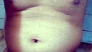 Old Indian gay bottom enjoys his own golden shower casually. He bends over for the flow.