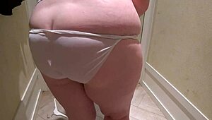 a hidden camera in the fitting room caught a mature chubby milf with a big booty trying on shorts.