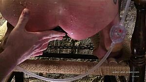 Syringed while kneeling, she endures intense anal stretching session