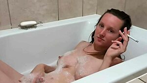 Petite amateur smokes in bath, exposing big tits and beautiful body.