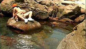 Does a mature man fuck an exotic babe on seaside stones?