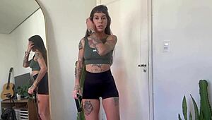 An inked girl warms up with rubber bands for her yoga fitness routine.