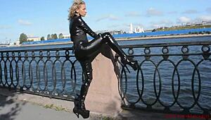 latex mona in a sexy suit and high heels walks down the street