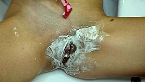 Close-up pov of shaving an unshaven pussy in the bathroom.