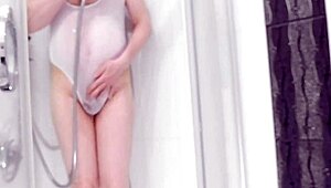 boy in see-through swimsuit plays with shower toy
